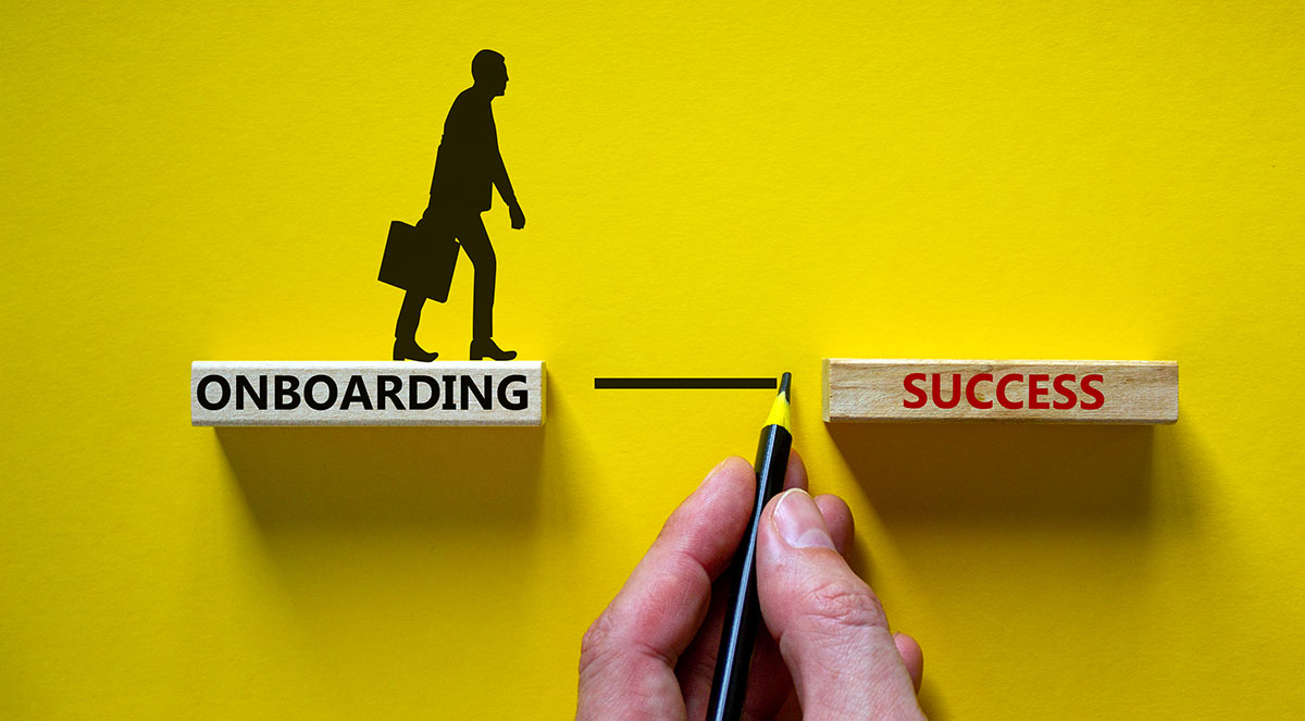 Onboarding success symbol. Wooden blocks with words 'onboarding success'. Businessman hand. Beautiful yellow background, copy space. Business and onboarding success concept.